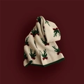 Close-up of beige Christmas knit scarf with green reindeer patterns on red background - Antler White