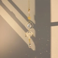 Macro view of crystal prism suncatcher with brass butterfly casting rainbow shadows - Ballet Butterfly Fairy