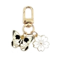 Golden keychain with black and white butterfly skull and white cherry blossom charm - Big Eyed Skull Butterfly + White Cherry Blossom