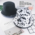 Flat lay of black and panda print cotton bucket hats with books and flowers on white background - M / Panda Pattern
