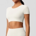 Détail d'un crop top de sport crème et d'un legging taille haute sur un mannequin - S / Hauts / Ivoire Clair