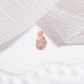 Macro-opname van roségouden druppelhanger met micro-geplaveide witte zirkonia steentjes - druppel / Roségoud