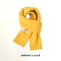 Détail d'une écharpe tricotée jaune pour enfant avec texture douce et étiquette de marque - Tricot Fin Jaune