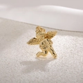 Macro shot of gold-plated cupid angel pendant with wings on textured stone background - Lucky Angel