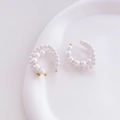 Macro shot of elegant white pearl C-shaped hoop earrings on a ceramic dish - Double Layer Ear Clip Style
