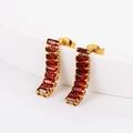 Detail shot of golden curved earrings featuring rectangular red zircon gemstones - Red Zirconia