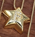 Star-shaped necklace in golden finish with a crystal-encrusted letter F pendant - Letter F