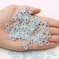Light blue pearl bow beads for DIY crafts held in hand to show small size detail - Light Blue