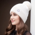 White cable knit beanie with faux fur pom and smiley face patch worn by model - One Size / White-Smile Face