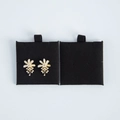 Floral pearl earrings with gold metal accents on black jewelry display cards - Black