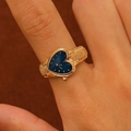 Macro shot of gold heart-shaped watch ring with blue dial worn on a model's finger - Gold Blue Heart Face (7899)
