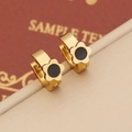 Macro shot of gold floral earrings with black enamel center and high polish finish - Flower Shape