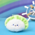 Detailed macro view of a cute plush dumpling charm with an adorable embroidered smiley face - Dumpling