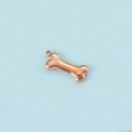 Detailed view of rose gold dog bone charm with amber zircon and metal ring - Rose Gold November