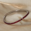Tennis bracelet with deep red cubic zirconia stones on silver base and golden satin backdrop - Steel Color/Red Zircon