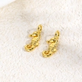 Macro shot of two polished golden seahorse charms for DIY handmade ocean jewelry - Seahorse / Gold
