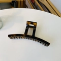Detailed top view of a large amber tortoiseshell hair claw clip with a polished finish - Glossy Light Tortoise