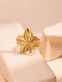 Elegant gold titanium steel ring with flower design on beige stone platform - Gold Flower Ring / Gold