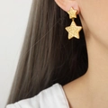 Boucles d'oreilles double étoile dorées avec motifs roses en relief portées par un modèle - Double Étoile Relief / Or (Étoile)
