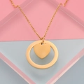 Close-up of golden stainless steel necklace with circle and heart pendant on colorful blocks - Gold
