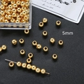 Vista macro de cuentas espaciadoras de cobre doradas de 5mm para hacer joyas - Oro de 18K 5mm (30 piezas)