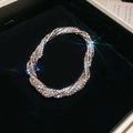 Dettaglio macro del bracciale multistrato con diamanti scintillanti su scatola di velluto - Argento