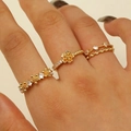 Dreiteiliges vergoldetes Ring-Set mit Blumendesign und Zirkonia-Akzenten am Modellfinger - 3-Teiliges Set Gold Blume Zirkonia Stil (9830)