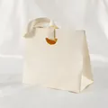 Elegant cream paper gift bag with textured finish and matching satin ribbon handles - 15.5*14.5*7.5cm / Beige