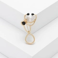 Spilla a stetoscopio dorata con pietre nere su sfondo bianco minimalista - Oro