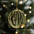 Glittering golden hollow 10cm Christmas ball ornament hanging on a festive tree branch - Gold