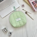 Detailed close-up of quilted light green shell makeup bag with pink zipper and handle - Green