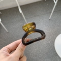Detailed close-up of tortoise shell pattern hair claw clip in amber brown finish - Glossy Tortoiseshell