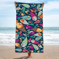 Quick-dry microfiber beach towel with colorful cartoon fish print held by a model on sand - Colorful Cartoon Fishes (STJ-019-007)
