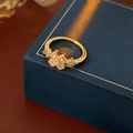 Makroaufnahme eines vergoldeten Kleeblatt-Rings mit Zirkonia auf einer Schmuckbox - Ring-Goldene Blume(WR482)