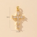 Dettaglio macro di un ciondolo a croce dorato da 3cm con zirconi a taglio smeraldo - Stile M-Mini Croce in Zircone Trasparente