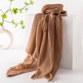 Brown cotton linen scarf with pleated texture and frayed edges on a white pedestal - Tan