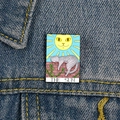 Detail of The Sun Tarot Cat enamel pin with feline sun and kitten on blue denim fabric - XC705-The Sun Grey White Cat