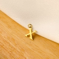 Detail of a shiny gold letter X pendant featuring a polished finish on wood and white cloth - 14k Letter - X (letter Height 1cm)