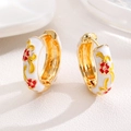 Macro detail of gold-plated hoop earrings with white enamel and red floral patterns - White (Zinc Alloy)