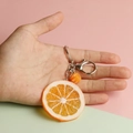 Realistic orange slice keychain with golden citrus texture and metal clasp on colorful background - Small Orange Slice