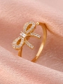 Elegant gold bow ring with zircon pavé and rectangular center stone on pink silk - Gold Zirconia Bow Tie Ring