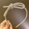 Primer plano de diadema plateada brillante con detalle de lazo de pedrería blanca fina - Lazo De Circonita Completa / Blanco