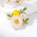 Spilla fiore margherita elegante con foglie in smalto verde e perla gialla su pietra bianca - Oro