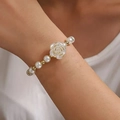 Elegant white rose pendant bracelet with faux pearls and golden beads on a female wrist - White Rose Pearl Gold (MY36766)