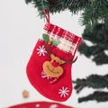 Detail of red Christmas stocking with plush reindeer doll and plaid cuff hanging on a tree - Small Bell Reindeer Stocking