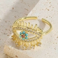Macro detail of gold evil eye ring with blue stones and dangling charms on stone - Blue Zirconia Dangle Ring