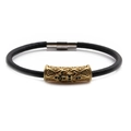 Close-up of leather bracelet featuring a gold cylinder charm with cross engraving - Gold F