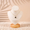 Detail of a gold necklace with a black clover pendant on a solid wood neck bust display - Small / Beige