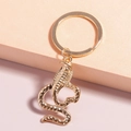 Elegante portachiavi a forma di cobra placcato in oro con trama a scaglie e anello - Cobra d'Oro