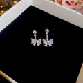 Boucles d'oreilles nœud en argent avec zircons étincelants dans un écrin de velours noir - Argenté